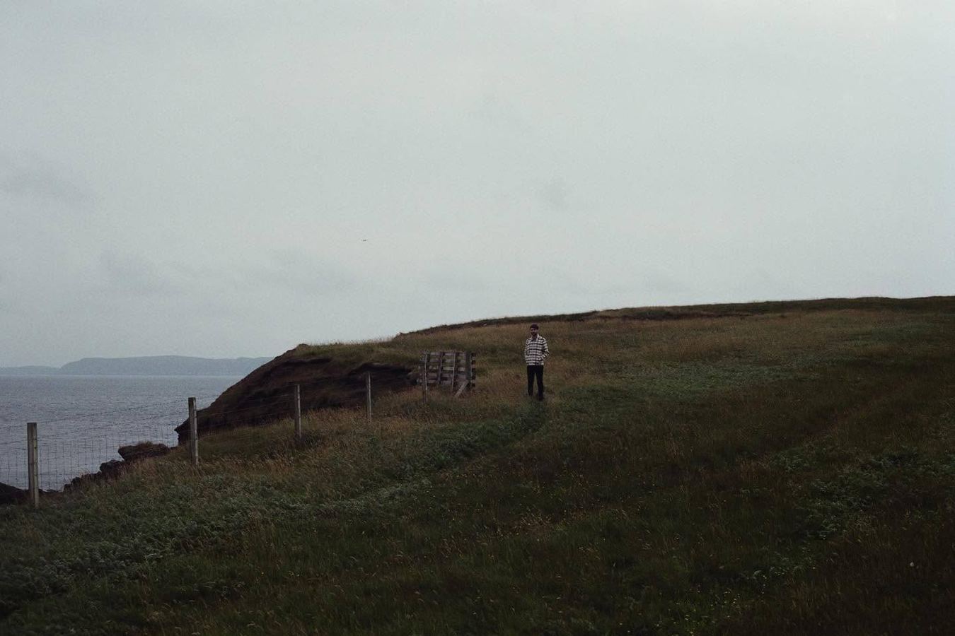 A walker on a misty coastal hillside