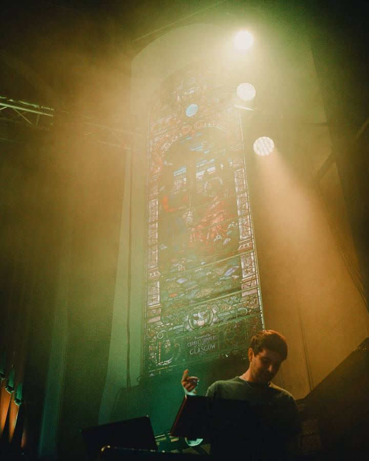 Callan performing live beneath a stained glass window in Glasgow